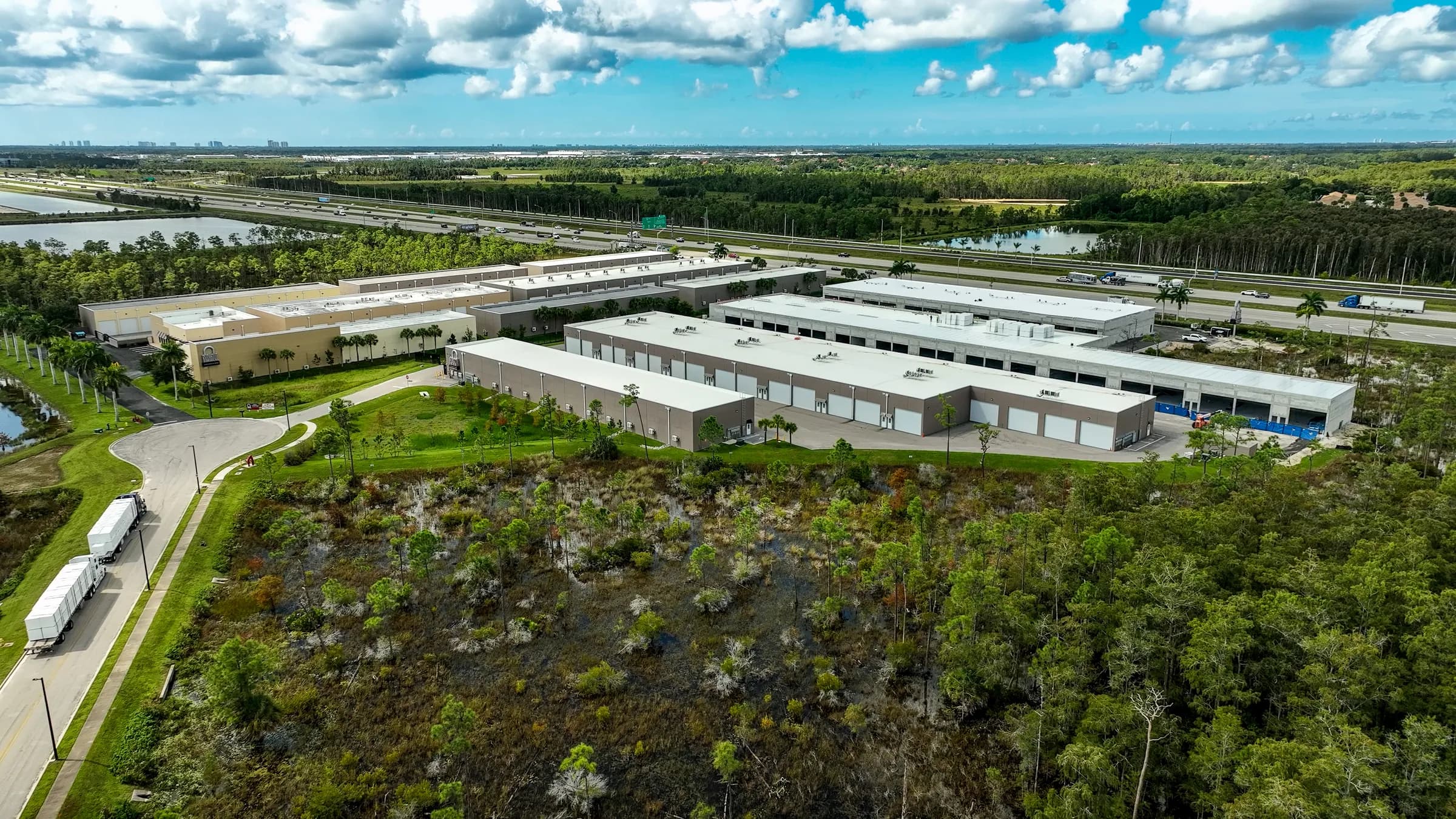 Aerial from the wetland side showing the newer building rows and the interstate beyond.