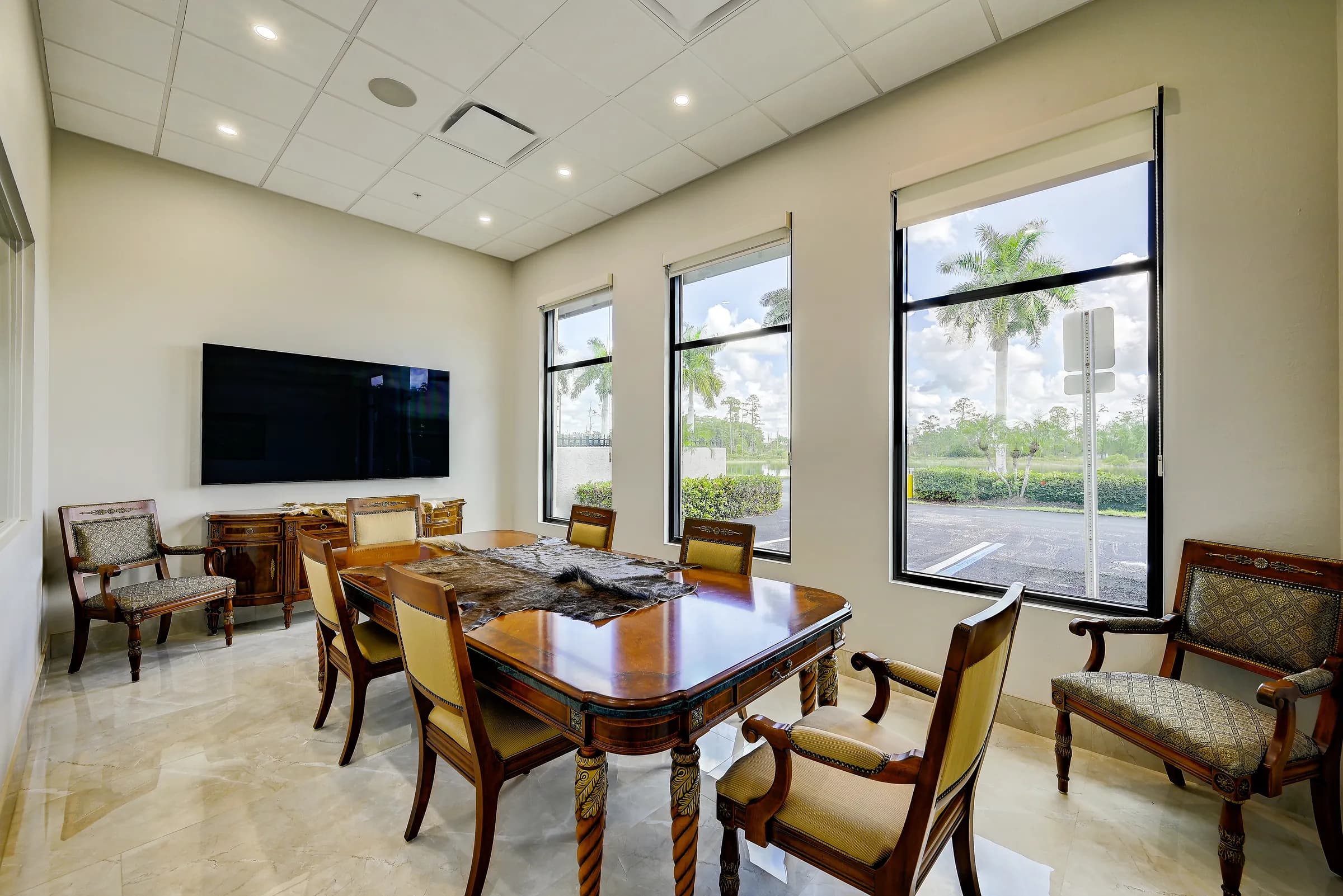 The conference room from the far corner, with the TV, side chairs and windows.