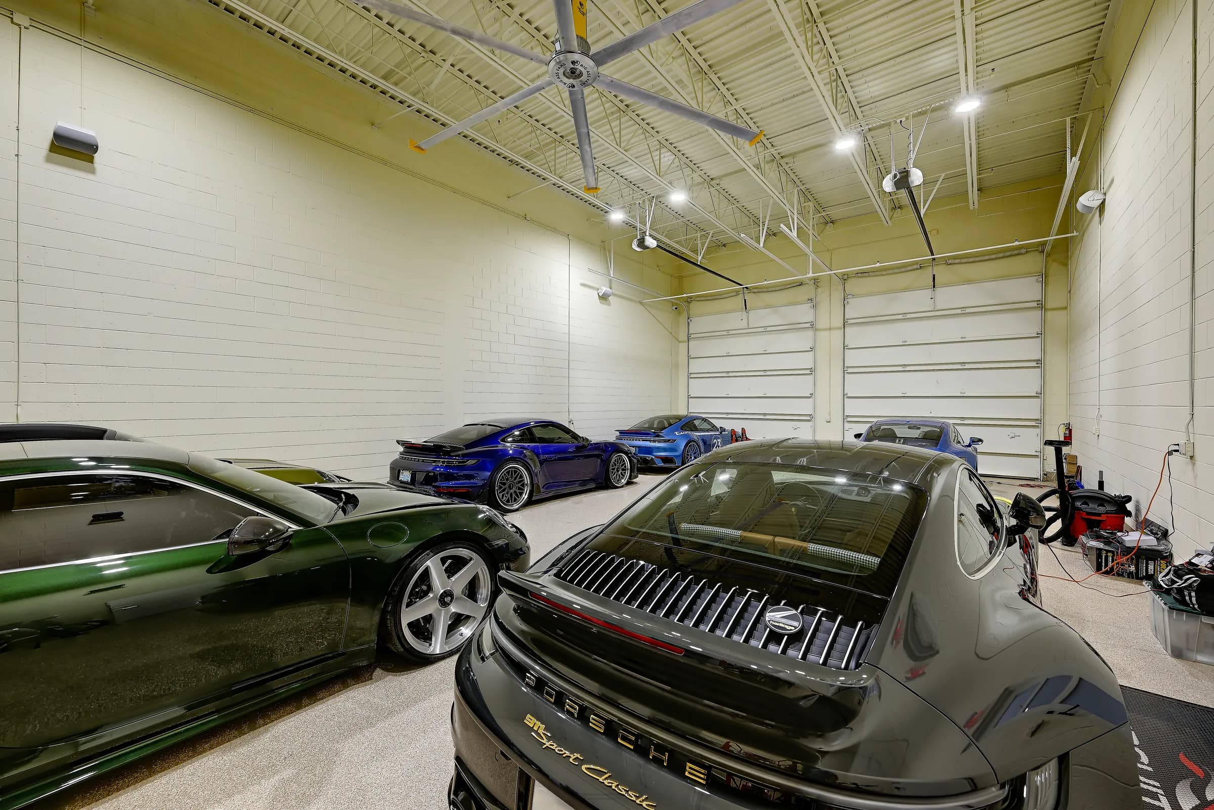The sports car collection unit looking toward the overhead doors, with green and grey coupes.