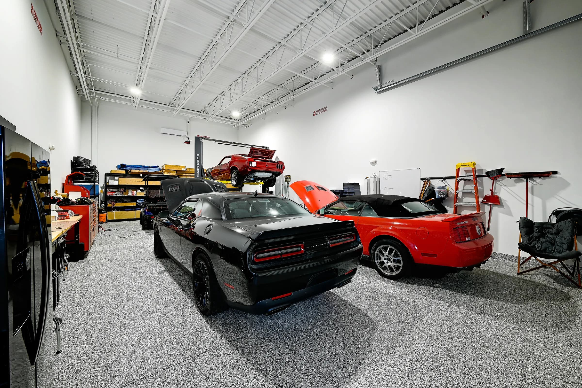The workshop unit from the rear, with a black muscle car and a red convertible.